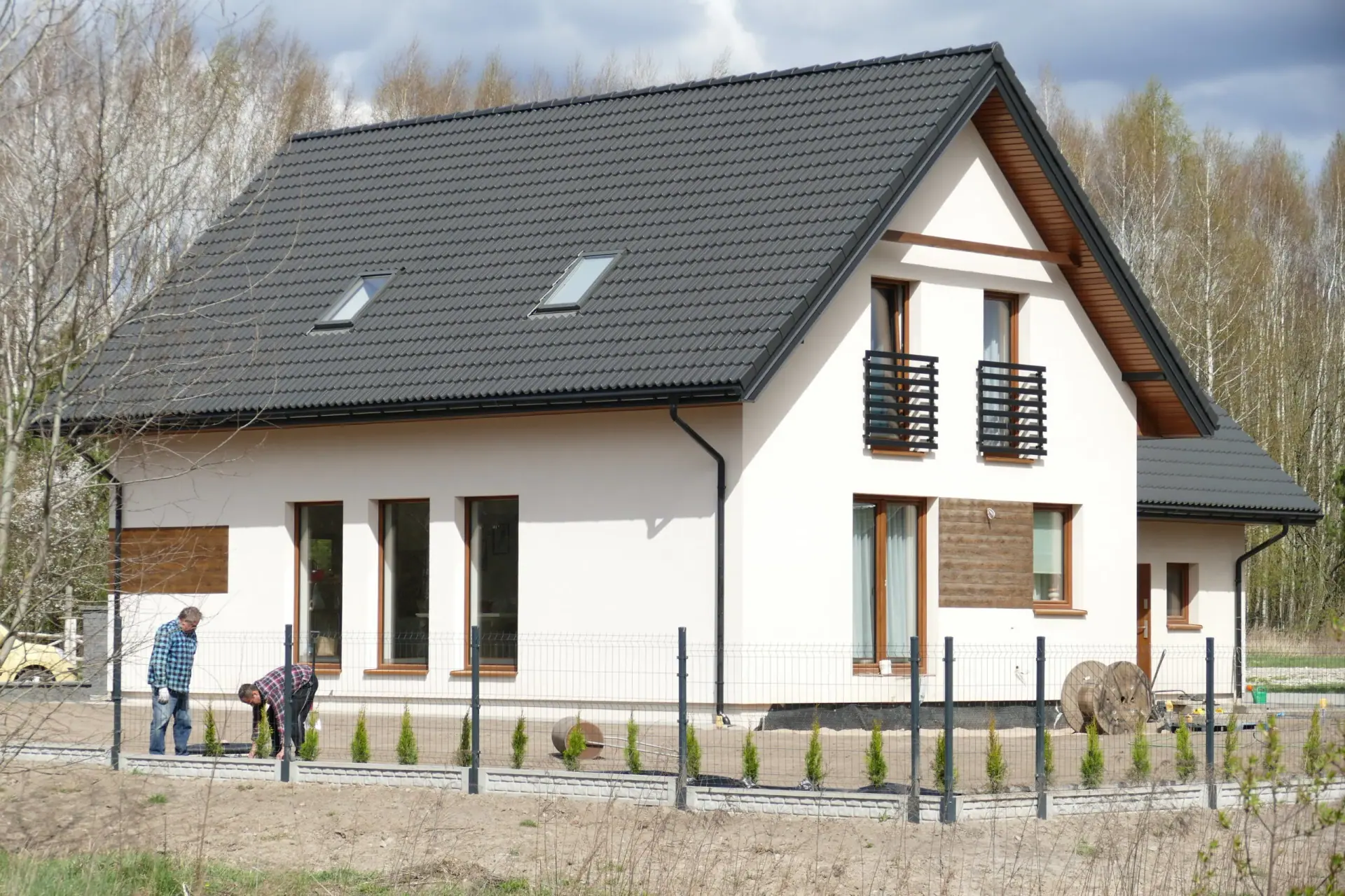 Wysoki dach dwuspadowy z kominem i oknem połaciowym