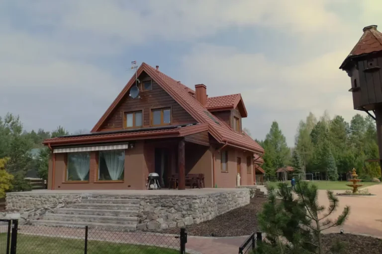 Dom z czerwonym dachem i rozbudowaną strefą wejścia