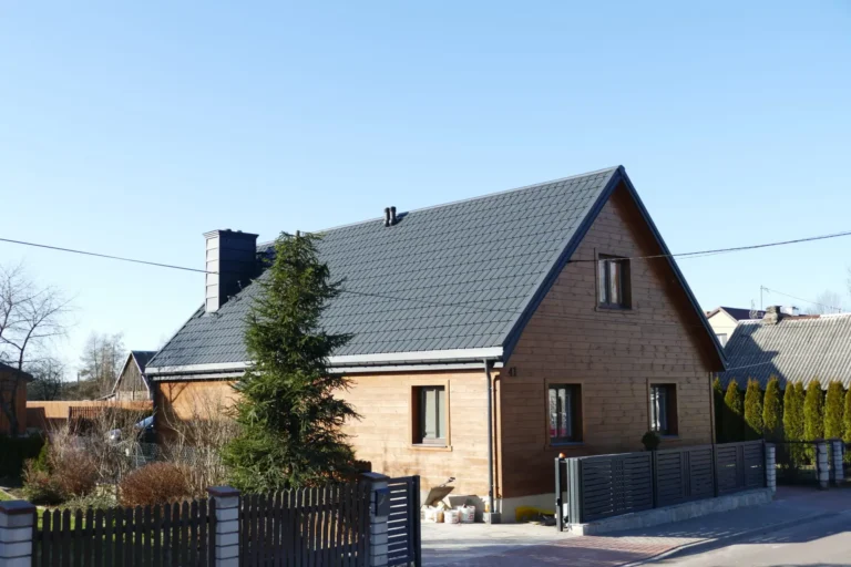Ciemny dach nad domem z ceglanym wykończeniem