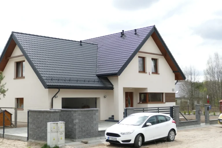 Dach dwuspadowy białego domu z przylegającym garażem