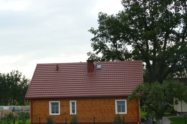 Czerwony dach nad drewnianym domem