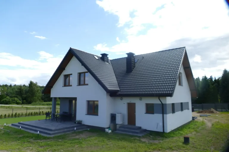 Ciemny dach dwuspadowy domu widziany od ulicy