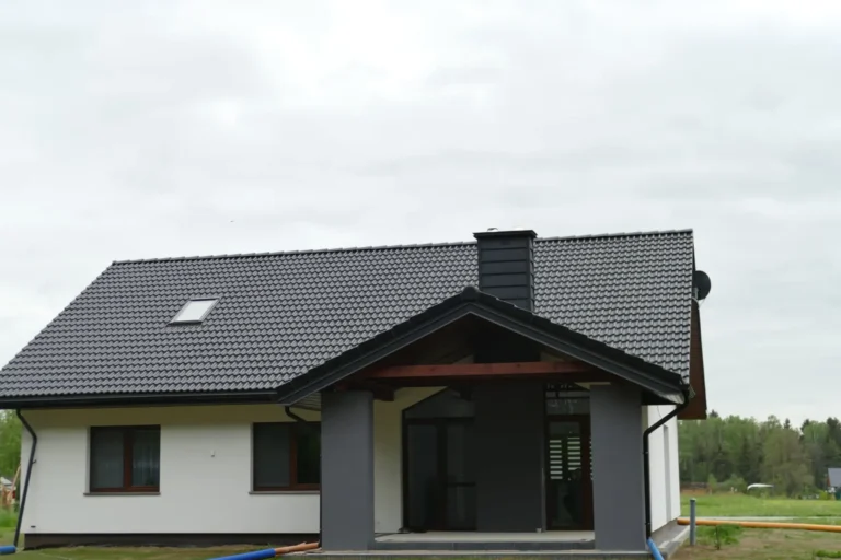 Ciemny dach dwuspadowy nad białym domem