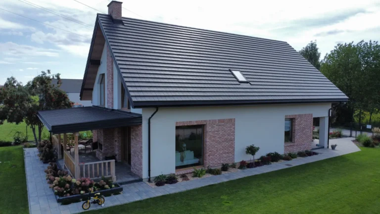 Ciemny dach nad domem parterowym z ogrodem