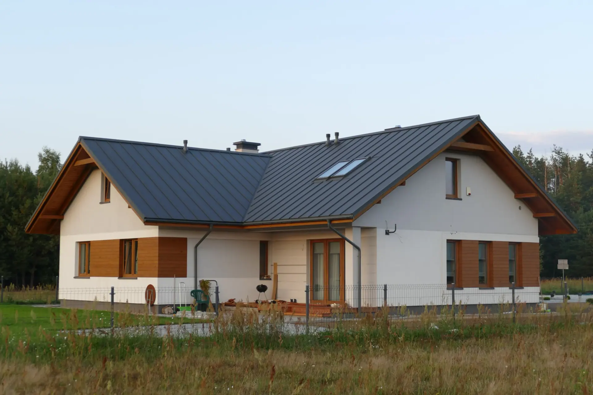 Szary dach nad domem z drewnianymi detalami