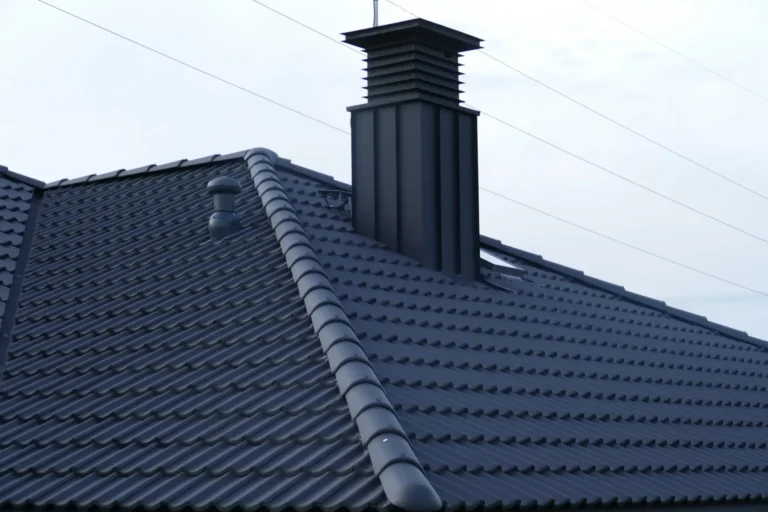 Komin na połaci ciemnego dachu domu