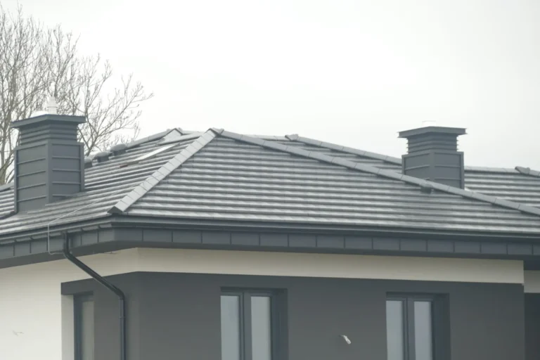 Widok komina i połaci szarego dachu