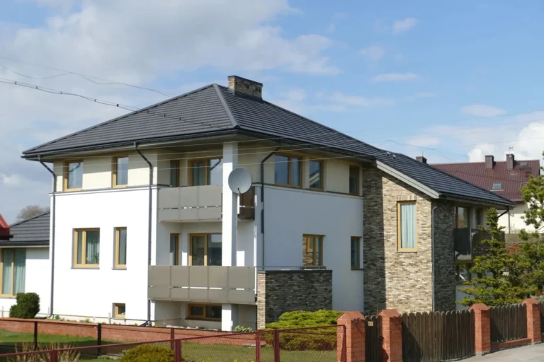 Dach domu o rozbudowanej bryle widziany od ulicy